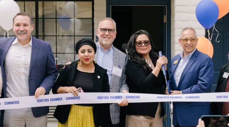 the group smiling and unveiling the newly renovated units during the progress celebration