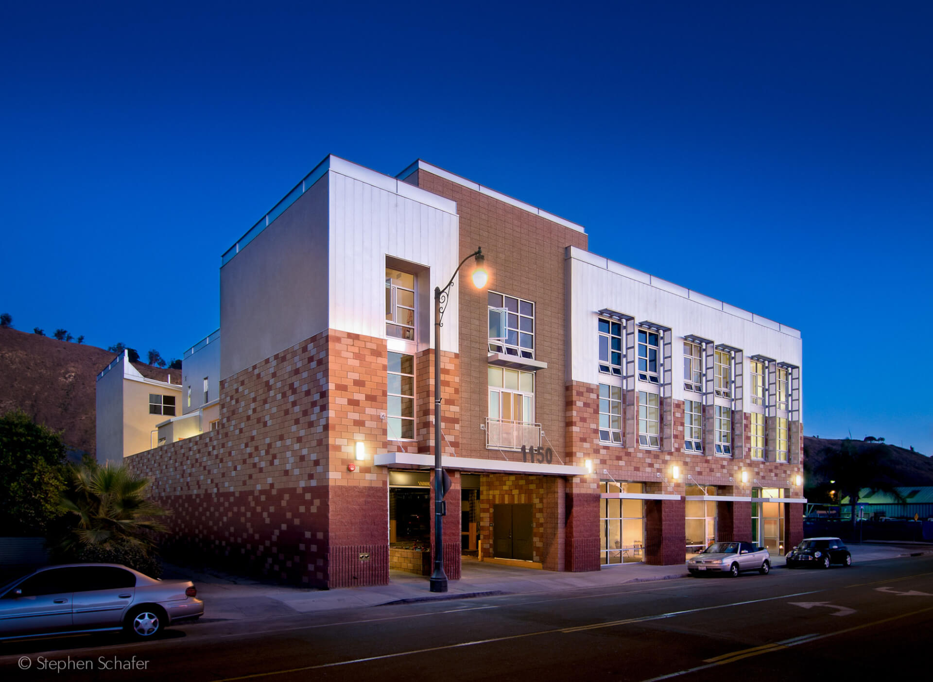 evening shot of building exterior with brick and lights on