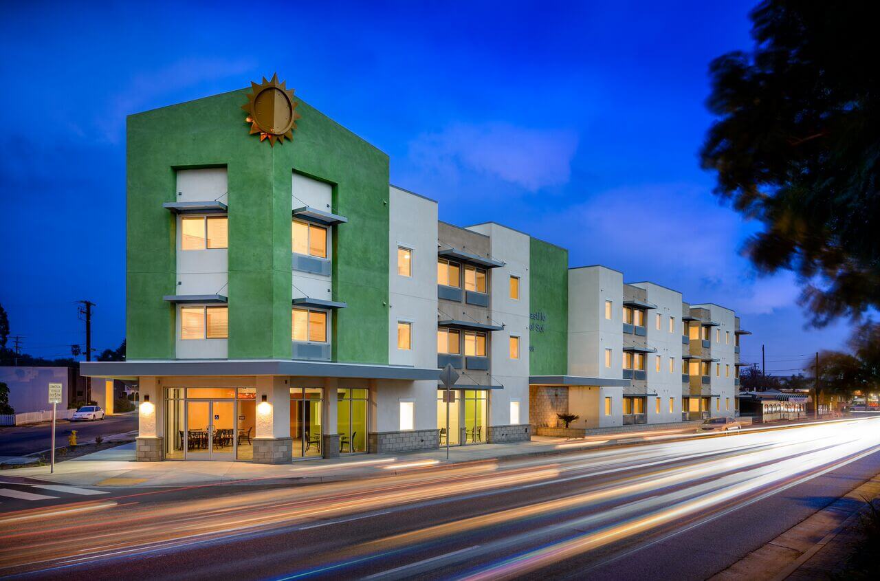 three story green and white building at night
