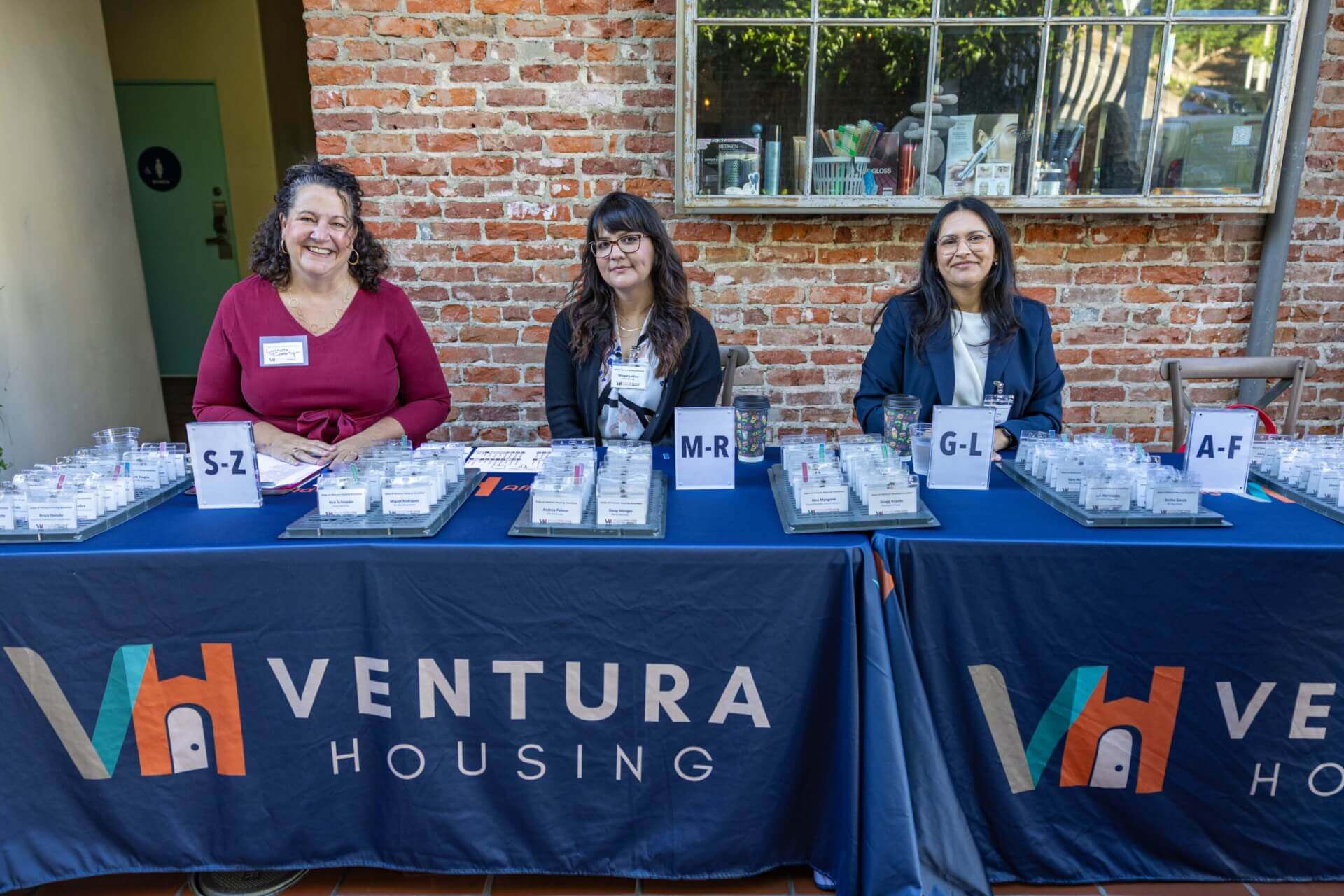 people sitting at the Ventura Housing tables handing out name tags